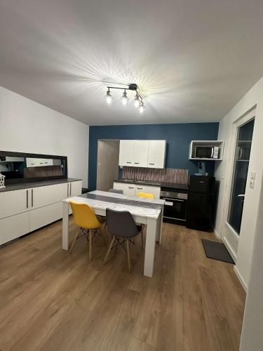 a kitchen with a white table and two chairs at 145 désirs in Samer