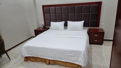 a bedroom with a large bed with white sheets and pillows at شقق لؤلؤه الفخامه in Al Qunfudhah