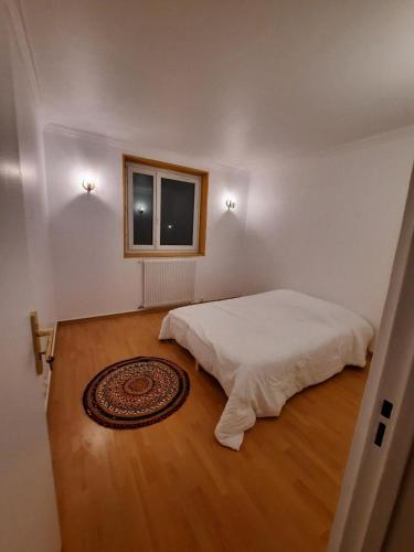 a bedroom with a white bed and a window at Chez Simon et Loreline Yerres proche Paris Orly Disney in Yerres