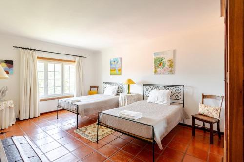 a bedroom with two beds and a table at Douro Valley-Casa do Vimieiro in Sande