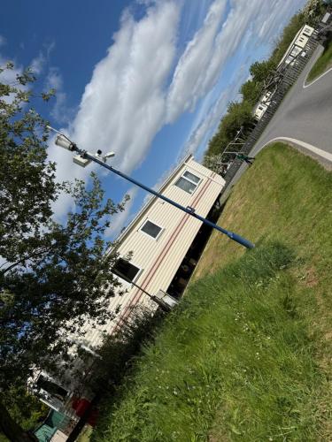a street light in the grass next to a house at Lake District Caravan Holiday in Millom