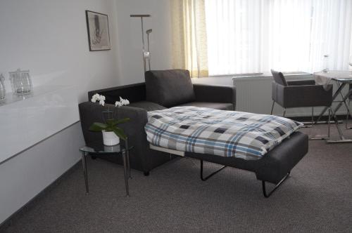 ein Wohnzimmer mit einem Sofa und einem Stuhl in der Unterkunft Altstadtappartement Königswinter in Königswinter