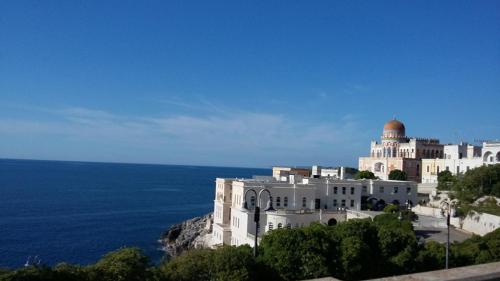 a building on a hill next to the ocean at B&B Le Rose in Vignacastrisi