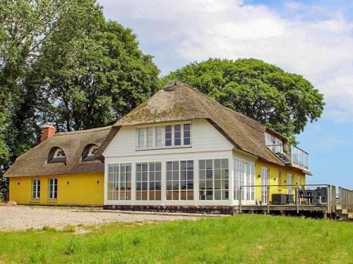 a yellow house with a thatched roof at 14 person holiday home in Havndal-By Traum in Havndal
