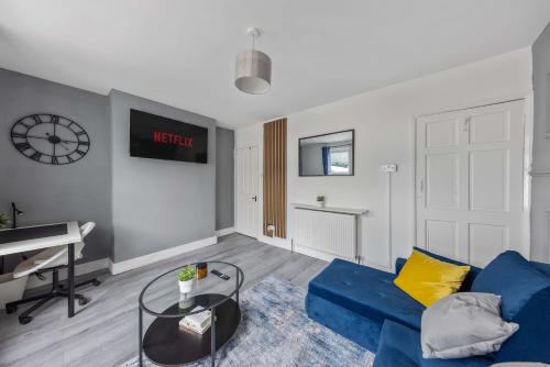 a living room with a blue couch and a piano at Cosy 2-Bed Home in the heart of Medway l Sleeps 5 in Gillingham