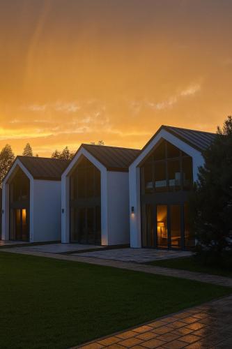 a white building with a sunset in the background at NATURA APARTAMENTY Era in Ulinia