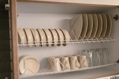 a refrigerator filled with plates and bowls on a shelf at Zona Rosa y Sector TURISTICO in Manizales