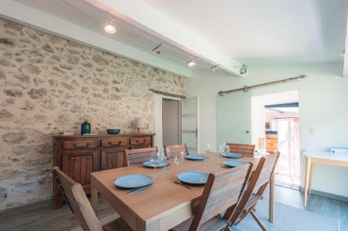 a dining room with a wooden table and chairs at L'Atypique - Cabanon 3 ch et terrasse au calme in Le Rove