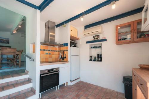a kitchen with a stove and a refrigerator at L'Atypique - Cabanon 3 ch et terrasse au calme in Le Rove