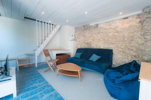 a living room with a blue couch and a table at L'Atypique - Cabanon 3 ch et terrasse au calme in Le Rove