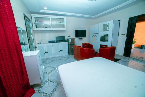 a room with a white table and red chairs at Residence Cabral in Guediawaye