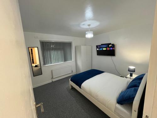 マンチェスターにある3 bedroom Luxurious property 5Mins from heaton parkのベッドとテレビのある寝室