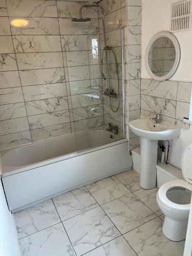 a bathroom with a tub and a sink and a toilet at 3 bedroom Luxurious Property in Manchester
