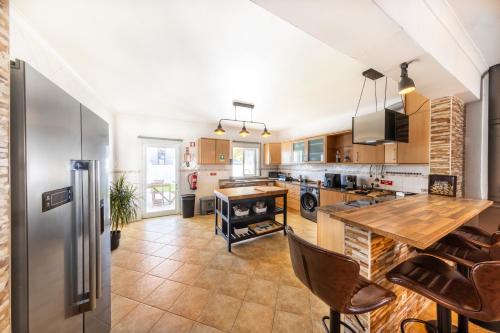 a kitchen with a table and a refrigerator at Sagres ZEN - 3 Bedroom House in Sagres