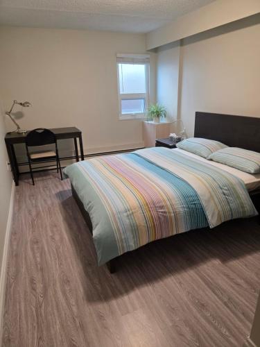 a bedroom with a large bed and a desk at Maplewood Hostel in Vancouver