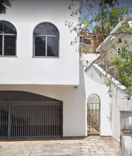 a white house with a black gate at Suite Conforto com ar e wi-fi, super bem localizado in Campinas