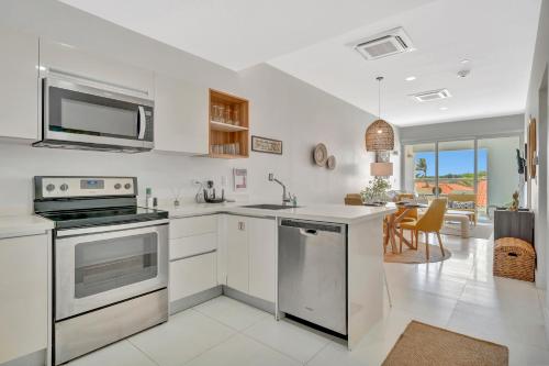a kitchen with white appliances and a living room at Arubas Life 212 in Noord