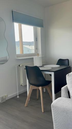 a room with a table and a chair and a window at Ilulissat City Apartments- Apartment 2 in Ilulissat