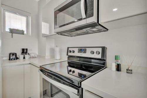 a white kitchen with a stove and a microwave at Arubas Life 212 in Noord