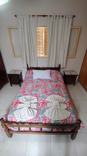 a bedroom with a bed with a floral quilt on it at Dpto Marina in Villa Cura Brochero