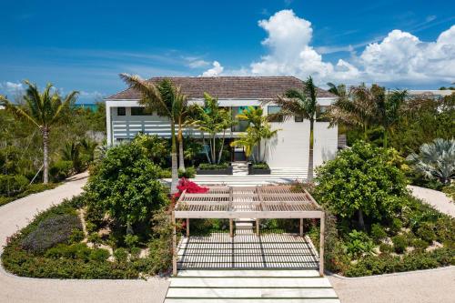 a woman sitting on a bench in front of a house at A magnificent villa that is perfect to enjoy a quiet vacation in Leeward