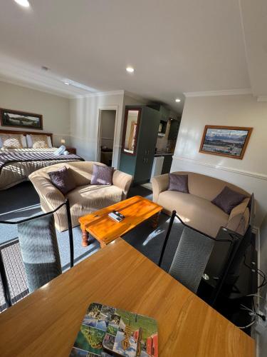 a living room with a couch and a table at Alpine Springs Motel in Hanmer Springs