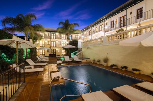 a swimming pool in front of a building at Don Antonio Posada in Colonia del Sacramento