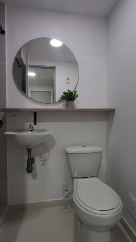 a bathroom with a toilet and a sink and a mirror at casa azul in Medellín