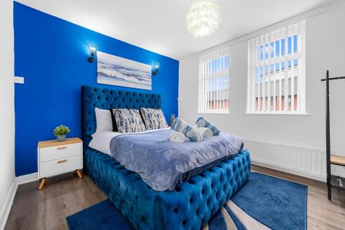 a blue bedroom with a bed with a blue wall at Prestige Rooms MCR - Close to City Centre-Etihad Stadium - Fast WIFI in Manchester