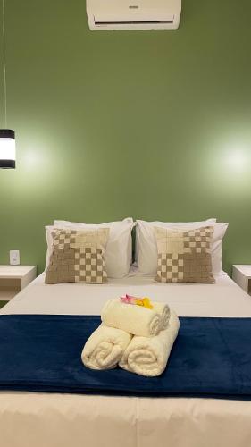 a bed with towels and pillows on it at Ypê Hospedagem II in Alto Paraíso de Goiás