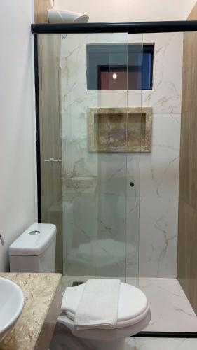 a bathroom with a shower with a toilet and a sink at Ypê Hospedagem II in Alto Paraíso de Goiás