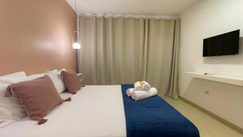 a bedroom with a large bed with a tv on it at Ypê Hospedagem II in Alto Paraíso de Goiás