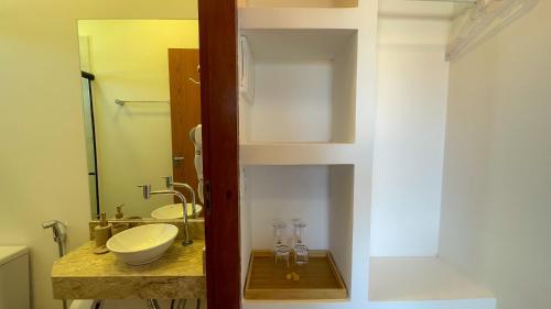 a bathroom with a sink and a mirror at Ypê Hospedagem II in Alto Paraíso de Goiás