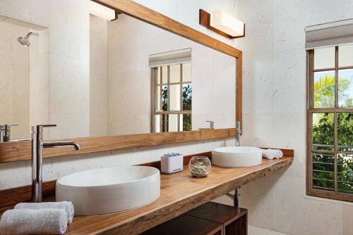a bathroom with two sinks and a large mirror at Compact one bedroom villa right on the beach in Turtle Cove
