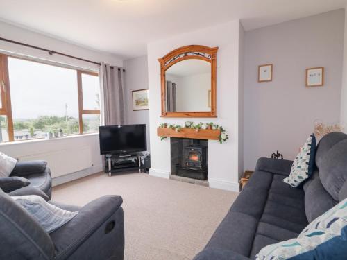 a living room with a couch and a mirror at Ard na Gréine in Kilrean