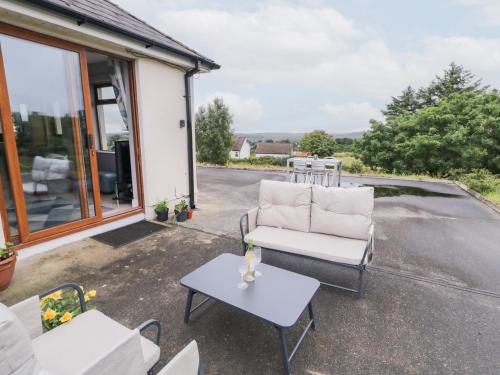 a patio with a chair and a table at Ard na Gréine in Kilrean