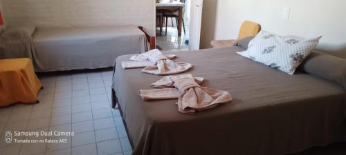 a bedroom with two beds with towels on a bed at Los Horneros in Villa Cura Brochero