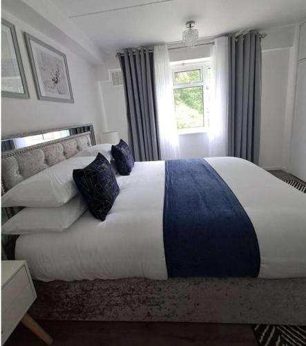 a bedroom with a large bed with pillows and a window at Three Bedroom Apartment in Brighton & Hove