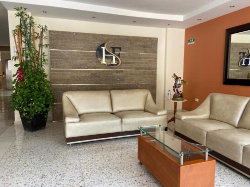a lobby with two couches and a sign on a wall at Hotel San Francisco in Barranquilla