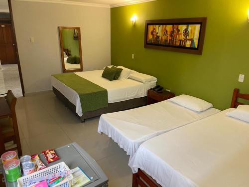 a hotel room with two beds and a mirror at Hotel San Francisco in Barranquilla
