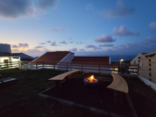 a backyard with a fire pit and benches at night at Azure Vista Lodge in Nordestinho