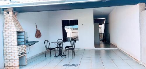 a patio with a table and chairs on a house at Casa Conforto in Senador Canedo