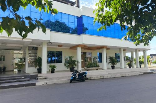 a scooter parked in front of a building at Hotel "EL INDI0" in Lago Agrio