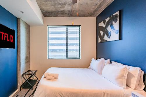 a bedroom with a large white bed with a blue wall at Relaxing 2BD - Central Downtown - Gym, Pool, Parking in Phoenix