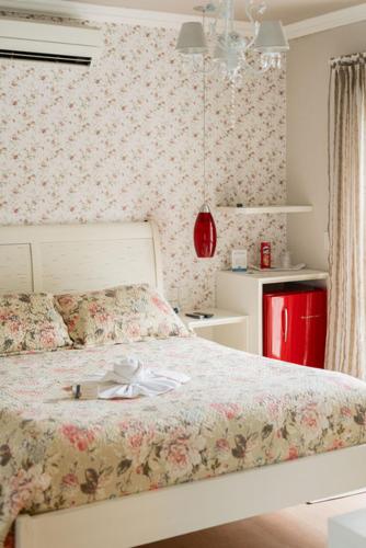 a bedroom with a bed with a flower patterned wall at Doce Canela - Pousada de Charme in Canela