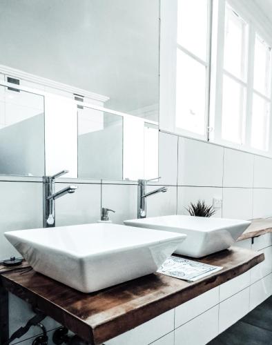 two white sinks on a wooden counter in a bathroom at Mad Monkey Broadway in Sydney