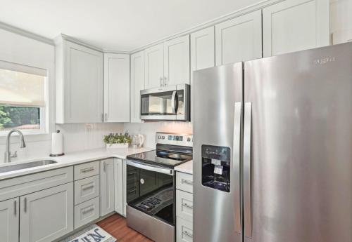 a kitchen with white cabinets and a stainless steel refrigerator at Marietta Charmer in Marietta