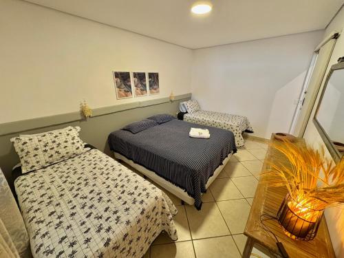 una camera con due letti e una sedia di Casa nova espaçosa e com ar condicionado a São Sebastião