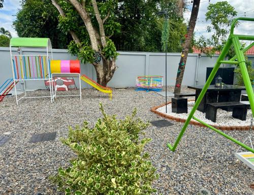 a backyard with a playground with chairs and a tree at SwanBB in Hang Dong