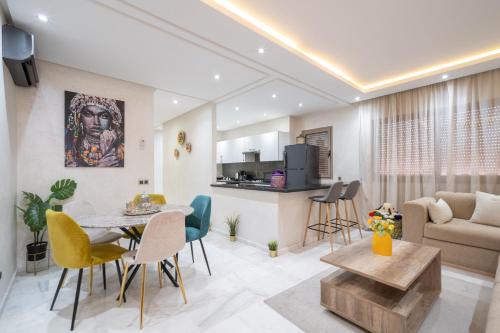 a living room and kitchen with a table and chairs at LUXURY APARTMENT IN THE HEART OF MARRAKECH GUELIZ in Marrakech